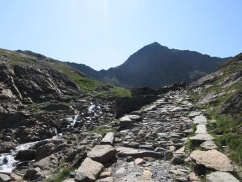 path leading up a hill, with mountain behind