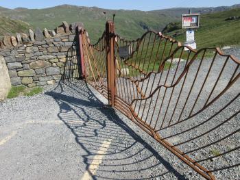 wavy metal gates, hill sloping down in background