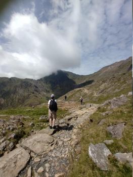 path stretching towards a mountain, with people along it