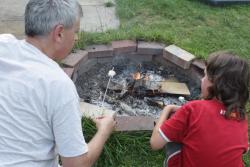 adult and child crouched by a fire